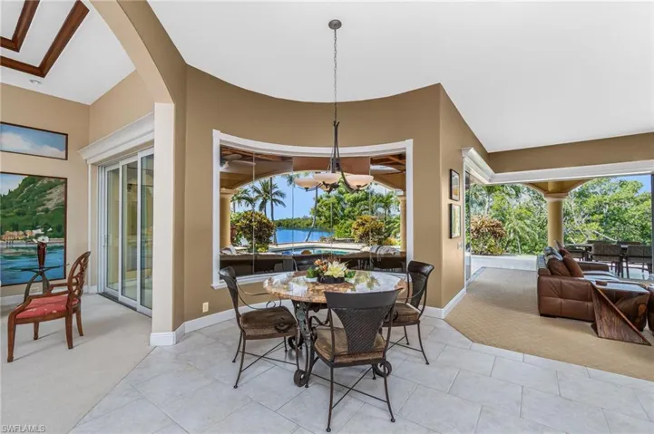 Dining space featuring light colored carpet, a chandelier, and a water view