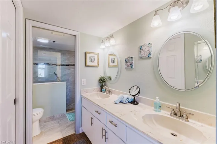 Bathroom featuring double vanity and a tile shower