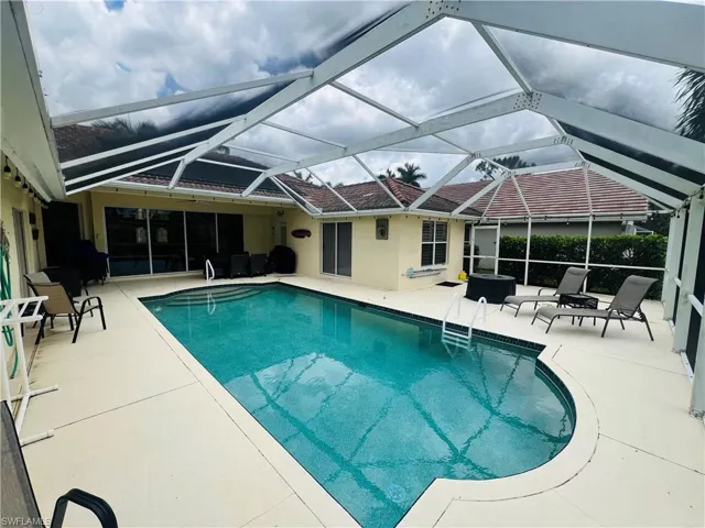 View of swimming pool featuring a patio area and a lanai
