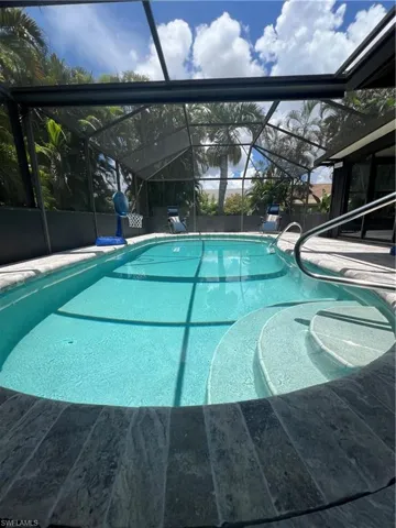 Outdoor pool featuring a lanai, a sunroom, and a patio area