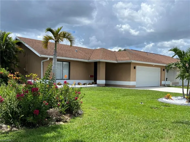 Ranch-style home with stucco siding, an attached garage, a shingled roof, a front yard, and driveway
