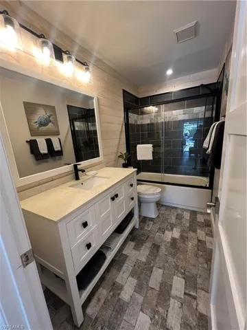 Bathroom with vanity and shower / bath combination with glass door