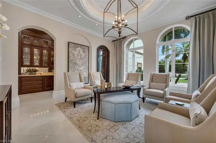 Sitting room featuring a tray ceiling, ornamental molding, and a chandelier