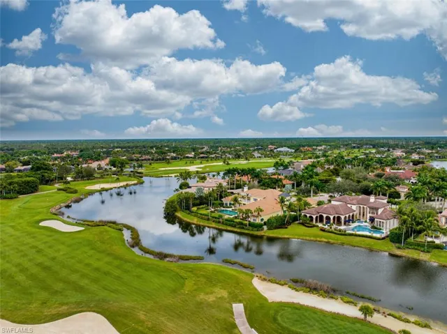 Aerial view of residential area with a golf course and a nearby body of water