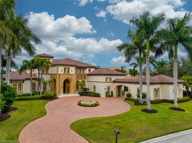 Mediterranean / spanish-style house with curved driveway, stucco siding, a balcony, a tile roof, and a front lawn