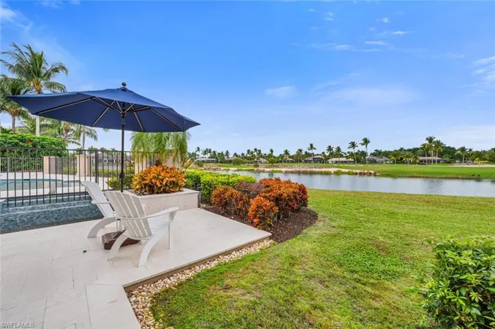 View of yard with a water view, a patio, and a pool with connected hot tub