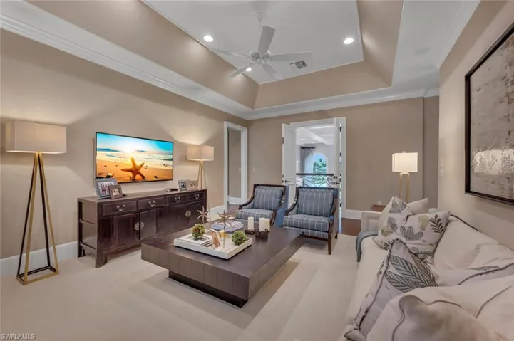 Living area featuring crown molding, a tray ceiling, ceiling fan, and recessed lighting