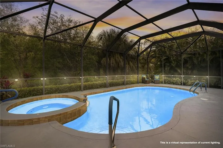 Pool at dusk with glass enclosure, an in ground hot tub, and a patio area