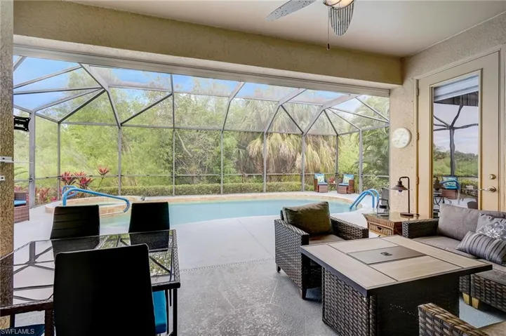 View of patio featuring glass enclosure and ceiling fan