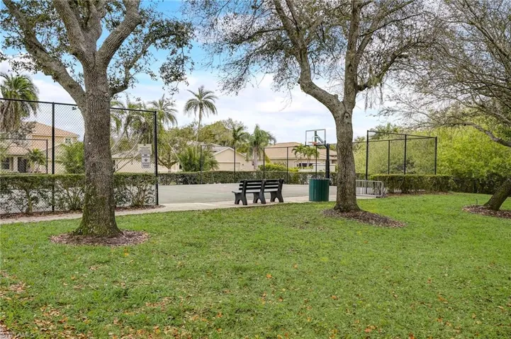View of community with a yard and basketball hoop