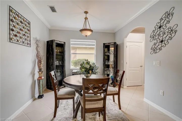 Tiled dining space featuring ornamental molding