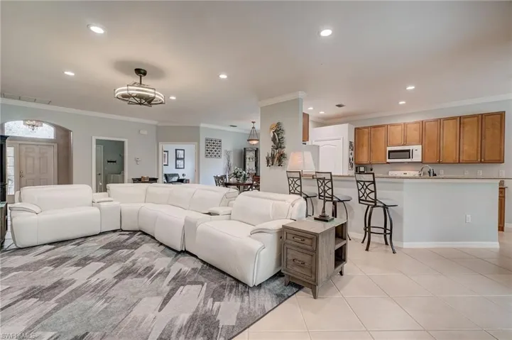 Tiled living room featuring sink and ornamental molding