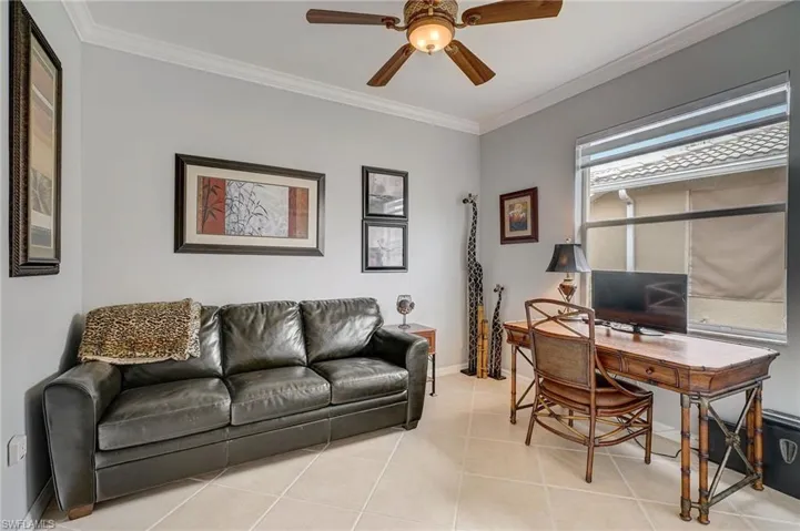 Tiled office space featuring ceiling fan and ornamental molding