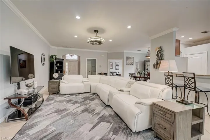 Living room featuring a notable chandelier and crown molding