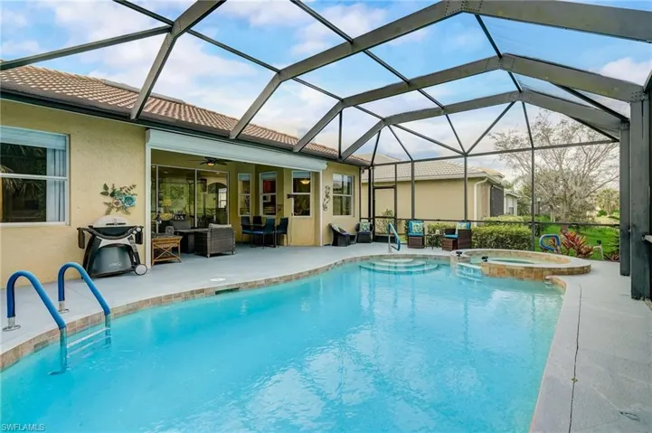 View of pool featuring a patio area, a lanai, an in ground hot tub, an outdoor hangout area, and ceiling fan