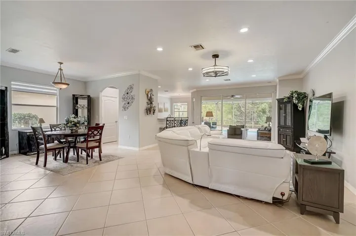 Living room featuring light tile patterned flooring and crown molding