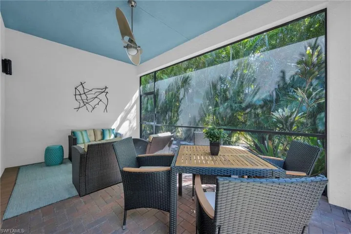 Screened lanai with covered seating area and peaceful, private garden views.