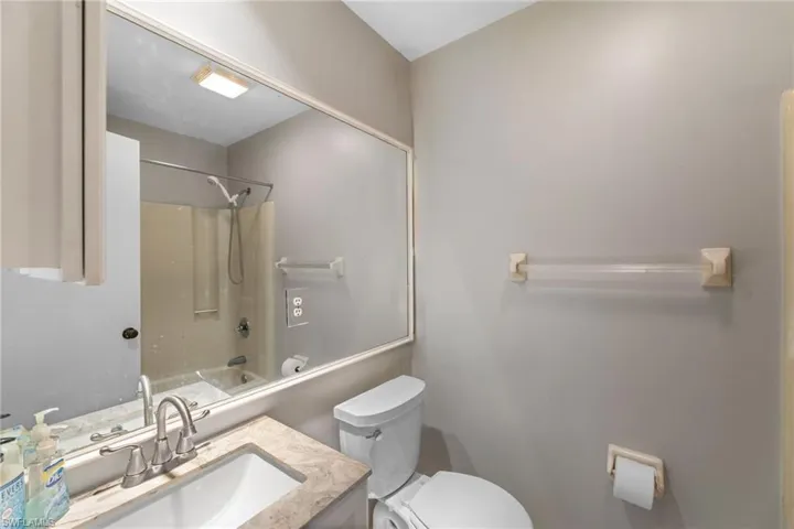 Bathroom featuring toilet, tub / shower combination, and vanity