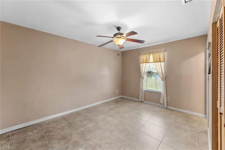 Spare room with ceiling fan and baseboards
