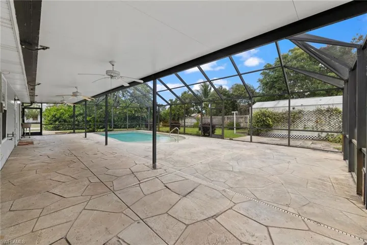 View of pool featuring a lanai, fence, a ceiling fan, a fenced in pool, and a patio area