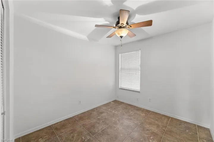 Spare room with a ceiling fan and baseboards