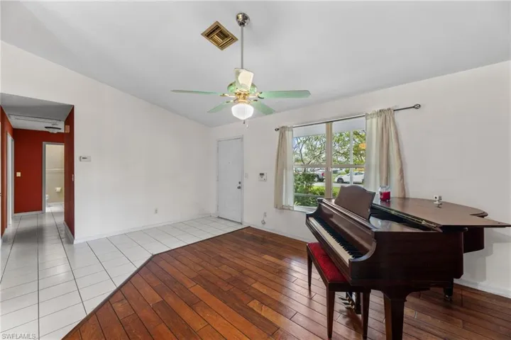 Sitting room featuring baseboards, light wood finished floors, visible vents, and a ceiling fan