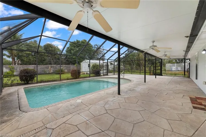 View of swimming pool featuring a storage shed, a fenced backyard, a patio area, and an outdoor structure