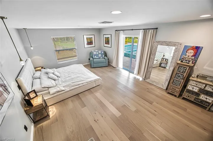 Bedroom with access to outside, light wood-style floors, and recessed lighting
