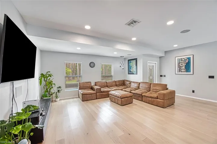 Living area featuring light wood-style flooring and recessed lighting