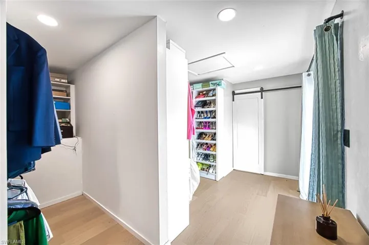 Spacious closet with wood finished floors and attic access
