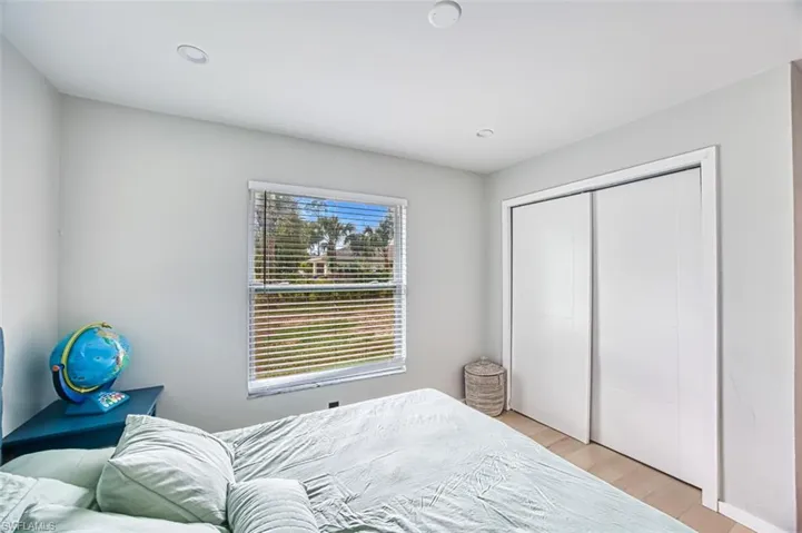 Bedroom with light wood-style floors and a closet