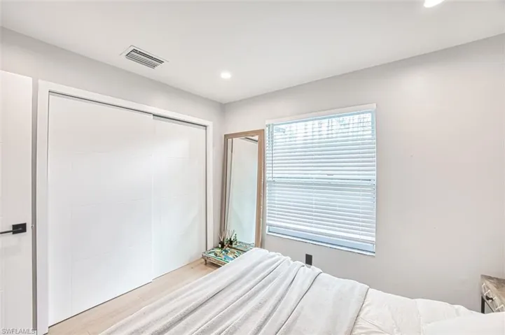 Bedroom featuring light wood-style floors, recessed lighting, and a closet