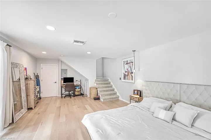 Bedroom with light wood-style flooring, an office area, and recessed lighting
