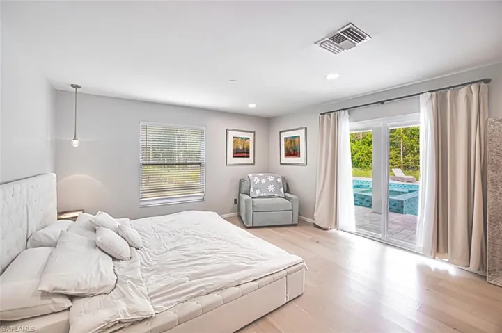 Bedroom featuring access to outside, light wood-type flooring, and recessed lighting