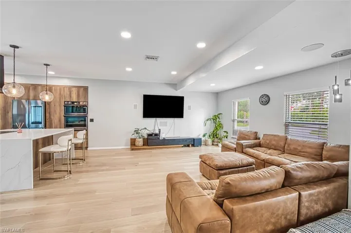 Living room with recessed lighting and light wood-style floors