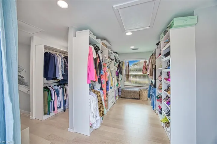 Spacious closet with light wood-style floors and attic access