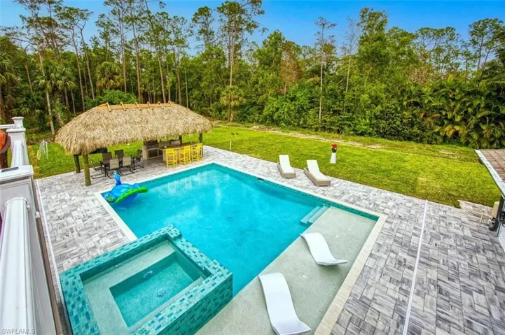 View of swimming pool featuring a yard, a patio area, a gazebo, and a pool with connected hot tub