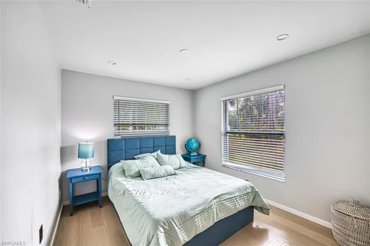 Bedroom featuring multiple windows, wood finished floors, and recessed lighting