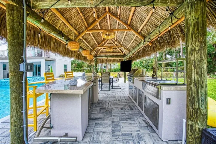 View of patio with area for grilling and a gazebo