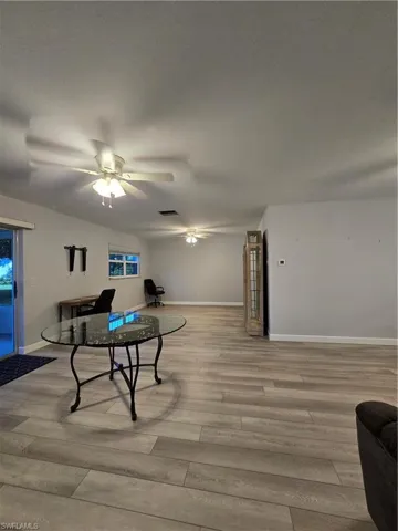 Living room with a textured ceiling, hardwood / wood-style floors, and ceiling fan