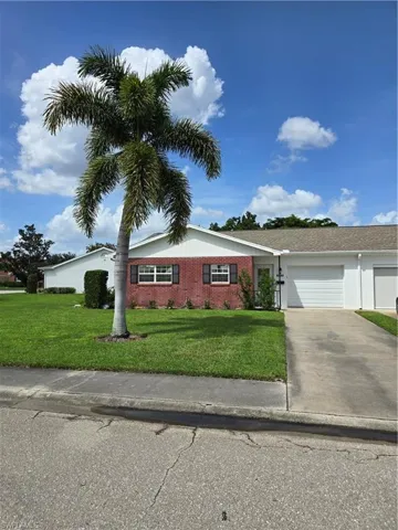 View of front of property featuring a garage and a front lawn