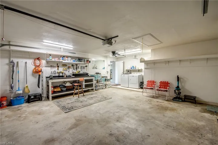 Garage with a workshop area, washer and dryer, and a ceiling fan