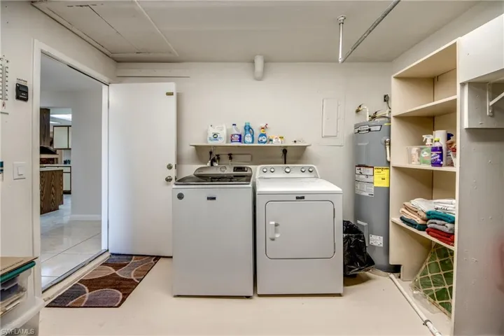 Laundry area with water heater, independent washer and dryer, and electric panel
