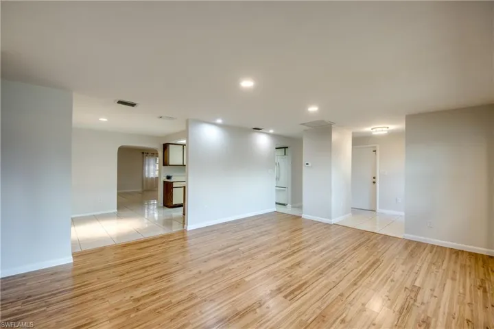 Spare room with arched walkways, light wood-type flooring, and recessed lighting