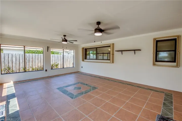 Unfurnished room featuring inlaid floor details, tile patterned flooring, and a ceiling fan