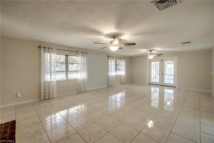Spare room with light tile patterned flooring, french doors, and a ceiling fan