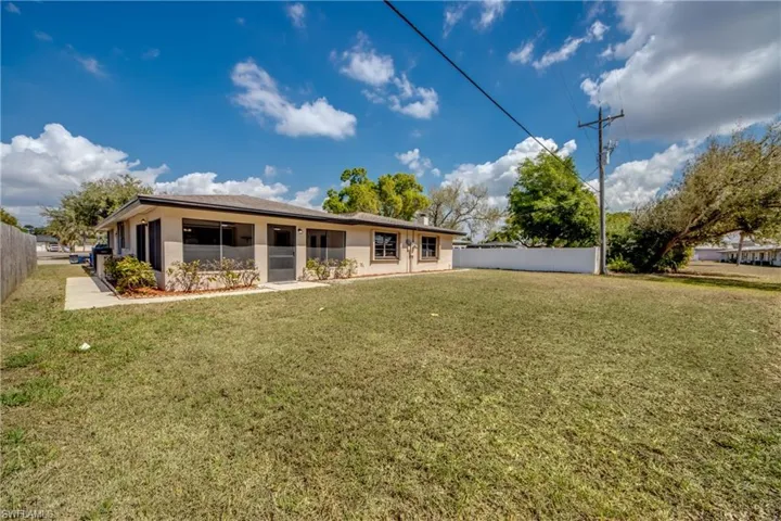 Rear view of property featuring stucco siding and a sunroom