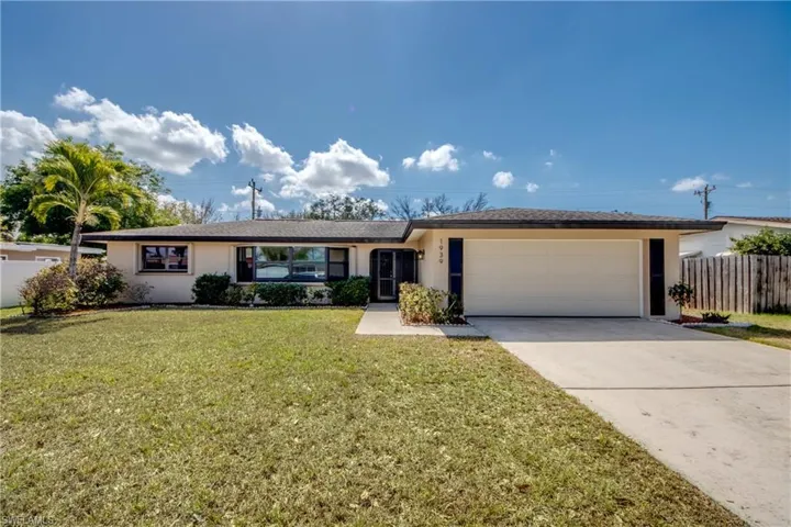 Ranch-style house featuring stucco siding, a garage, and driveway