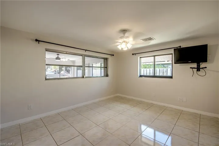 Empty room featuring a ceiling fan and light tile patterned floors
