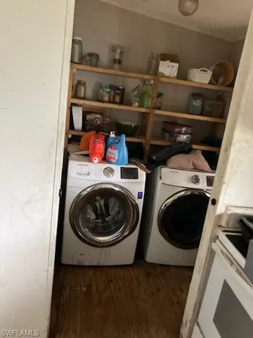 Laundry area with independent washer and dryer and dark hardwood / wood-style floors